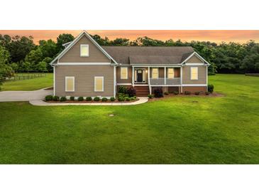 Charming home featuring a cozy front porch and well-manicured lawn at 727 Sonny Boy Ln, Johns Island, SC 29455