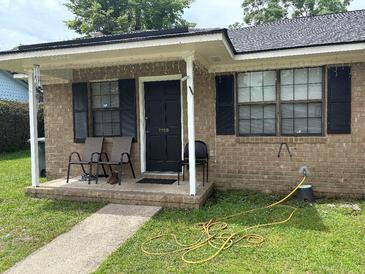 Charming brick home with a cozy front porch perfect for relaxing and enjoying the neighborhood views at 7709 Suzanne Dr, North Charleston, SC 29418