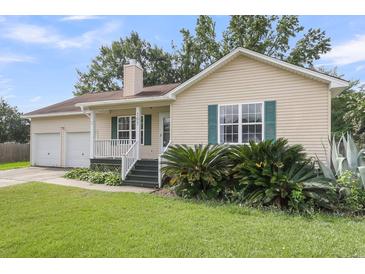 Charming single-story home with well-manicured lawn, lush landscaping, and a welcoming front porch at 105 Conductor Ct, Summerville, SC 29486