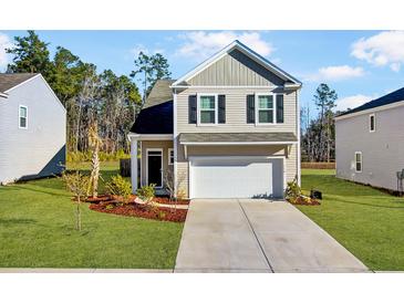 Charming two-story home featuring a manicured lawn and an attached two-car garage at 110 Cardinal Flower Ct, Moncks Corner, SC 29461