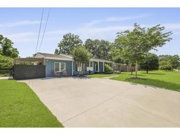 Charming blue home boasts a well-manicured lawn and a large concrete driveway and inviting curb appeal at 2605 Mona Ave, Charleston, SC 29414