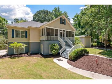 Charming home featuring a screened front porch with white railings, a gray foundation, and mature landscaping at 2649 Starfish Dr, Johns Island, SC 29455