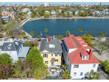 Stunning yellow home with backyard patio and waterfront views of Charleston's harbor and historic skyline at 49 Ashley Ave, Charleston, SC 29401