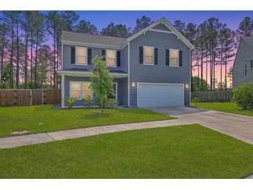 Charming two-story home with a well-manicured lawn and attached two car garage at 504 Sarno Way, Summerville, SC 29486