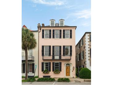 Charming pink three-story house featuring black shutters, window boxes, and a classic wooden front door at 55 E Bay St, Charleston, SC 29401