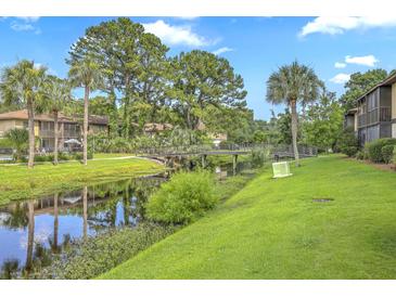 Scenic view of the community featuring a waterway, bridge, lush landscaping, and neighboring condo buildings at 2174 Bees Ferry Rd # G, Charleston, SC 29414