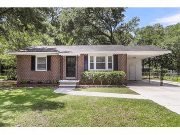 Charming red brick home featuring a well-manicured lawn, traditional design, and convenient carport at 2631 Ridgewood Ave, Charleston, SC 29414