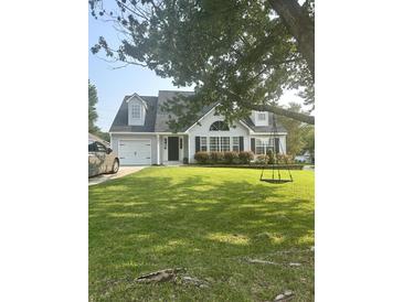 Charming one-story home featuring an attached garage and a lush green lawn with a tree swing for outdoor enjoyment at 340 Mount Royall Dr, Mount Pleasant, SC 29464