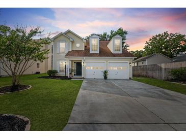 Charming two-story home featuring a well-manicured lawn, two-car garage, and inviting curb appeal at 8340 Coventry Ct, North Charleston, SC 29420