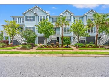 Charming light-blue townhouses with well-maintained landscaping and inviting staircases leading to the front doors at 1582 Prince Edward St, Mount Pleasant, SC 29466