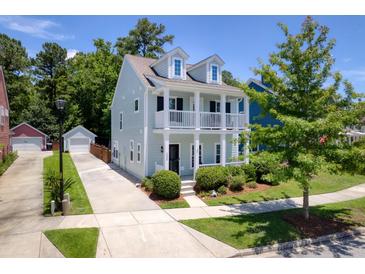 Charming two-story home with a double porch, lush landscaping, and a detached garage at 1666 Sparkleberry Ln, Johns Island, SC 29455