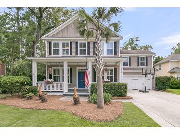 Charming two-story home with a welcoming front porch, beautiful landscaping, and an American flag at 1728 Wellstead St, Mount Pleasant, SC 29466