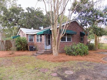 Charming brick home featuring awnings, landscaped front yard, and a cozy, welcoming entrance at 3034 Maybank Hwy, Johns Island, SC 29455
