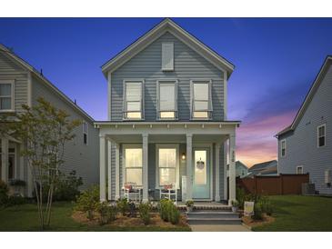 Charming two-story home featuring a cozy front porch with seating, a welcoming entrance and manicured landscaping at 330 Ripple Park Dr, Summerville, SC 29486