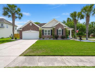 Charming brick home with an attached garage, well manicured lawn, and stately palm trees at 7030 Billberry St, Hanahan, SC 29410