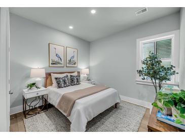 Serene bedroom featuring soft lighting, neutral decor, and a plush bed at 7631 Indigo Palms Way, Johns Island, SC 29455