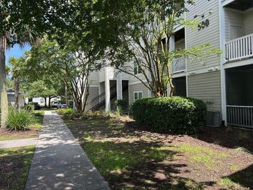 Inviting condo building with lush landscaping, sidewalks, and stairs leading to upper-level units at 1300 Park West Blvd # 519, Mount Pleasant, SC 29466