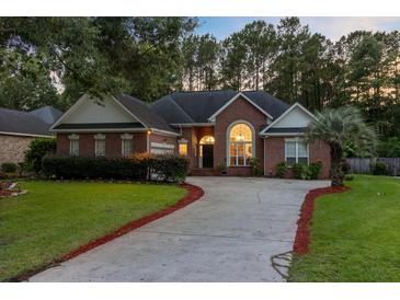 Charming brick home with mature trees, lush lawn, and a well-manicured front yard, full of curb appeal at 4209 Wildwood Lndg, Charleston, SC 29420