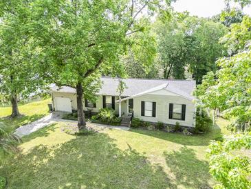 Charming single-story home featuring a well-manicured lawn and beautiful mature trees at 5 Drummond Ct, Charleston, SC 29414