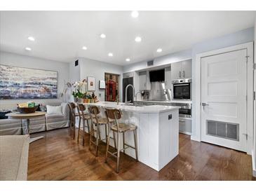 Bright, modern kitchen with stainless steel appliances, a large island, and bar seating. Hardwood floors give a polished look at 1481 Center Street Extension # 1102, Mount Pleasant, SC 29464