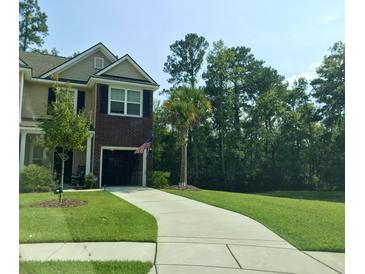 Charming two-story home with a brick accent, open garage, landscaped front yard, and long driveway at 1720 Restoration Ct, Charleston, SC 29414