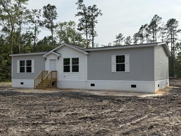 Charming single-story home with gray siding, white trim, and a welcoming front porch at 18441 Round O Rd, Round O, SC 29474
