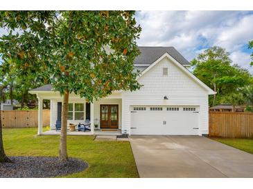 Charming two-story home with white siding, covered front porch, and attached two-car garage at 217 7Th Ave, Mount Pleasant, SC 29464