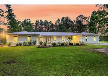 Charming single-story home with lush lawn, fresh landscaping, and a metal roof at 242 Cheyenne Rd, Summerville, SC 29483