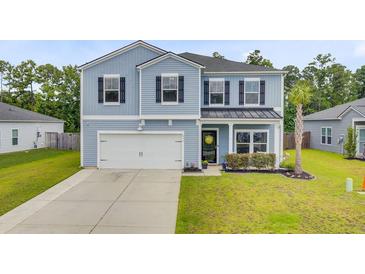 Charming two-story home with a well-maintained lawn and attached two car garage at 493 Spanish Wells Rd, Summerville, SC 29486