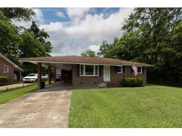 Charming brick home with a covered carport, mature trees, and a well-maintained front lawn at 5209 Sterrett St, North Charleston, SC 29405