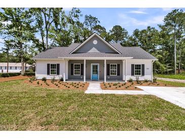 Charming single-story home featuring a covered porch, gray accents, and well-maintained landscaping at 6513 Highway 162, Hollywood, SC 29449