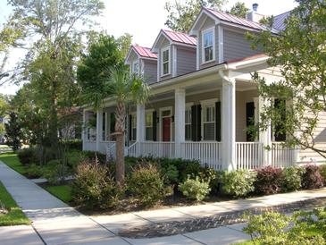 Charming two-story home with a inviting front porch, landscaped yard, and red roof at 7021 Schooner St, Charleston, SC 29492