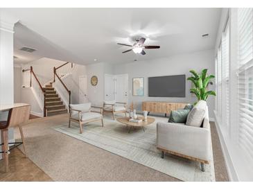 Bright living room featuring neutral tones, modern furnishings, and a staircase leading to the upper level at 705 Quintan St, Summerville, SC 29486