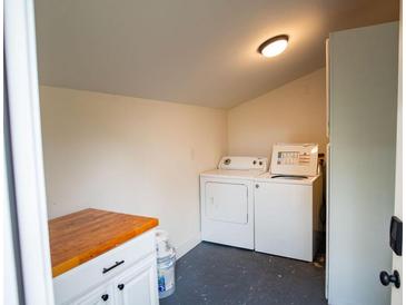 This charming laundry room has white appliances, ample space, and a butcherblock folding table at 1137 Dickson Ave, Hanahan, SC 29410