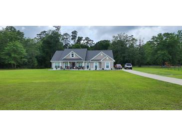 Charming single-story home with well-manicured lawn, inviting porch, and long driveway at 148 Hidden Hills Rd, Cross, SC 29436