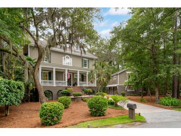Charming two-story home with landscaped yard and inviting front porch, exuding Southern charm and curb appeal at 1612 John Fenwick Ln, Johns Island, SC 29455