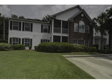 Charming two-story home boasts a well-manicured lawn, inviting curb appeal, and a delightful screened porch at 163 Golfview Ln, Summerville, SC 29485