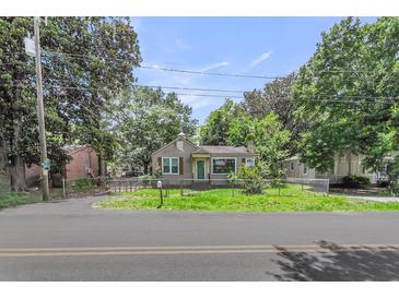 Charming single-story home with a grassy front yard, chain link fence, and mature trees providing ample shade at 2665 Ranger Dr, North Charleston, SC 29405