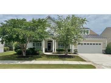Charming home with a well-manicured lawn, mature trees, and inviting front porch at 310 Waterlily Way, Summerville, SC 29486