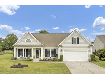 Charming home featuring a two-car garage, well-manicured lawn, and inviting front porch with comfortable seating at 349 Waterlily Way, Summerville, SC 29486