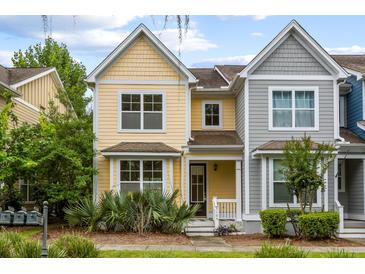 Charming two-story yellow home with a well-maintained front yard, featuring a cozy porch at 5104 E Liberty Park Cir, North Charleston, SC 29405