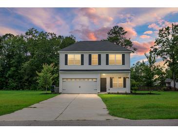 Two-story home with white siding, black shutters, a two-car garage, and a well-manicured front lawn at 717 Butter Rd, Bonneau, SC 29431