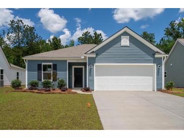 Charming single-story home with blue siding, well-manicured lawn, and a two-car garage at 122 Royal Cainhoy Way, Huger, SC 29450