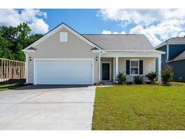 Charming single-Gathering home showcasing a two-car garage and a well-maintained front lawn and traditional design at 153 Royal Cainhoy Way, Huger, SC 29450