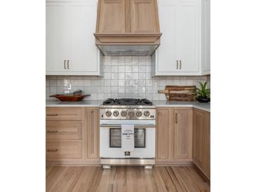 A beautifully designed kitchen featuring custom cabinetry, a professional range, and stylish accents at 1532 Sea Palms Cres, Mount Pleasant, SC 29464