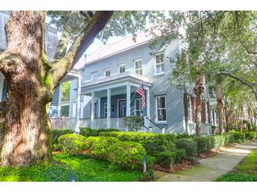 Charming home featuring a welcoming porch, American flag, and lush landscaping at 183 Ionsborough St, Mount Pleasant, SC 29464