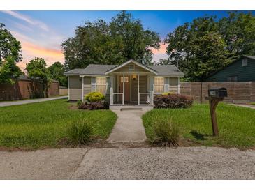 Charming single-story home features a well-manicured lawn and inviting front porch with a mailbox on the side at 1940 Orangeburg St, North Charleston, SC 29405