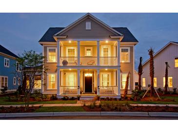 Charming two-story home with a double porch, manicured lawn, and inviting curb appeal at dusk at 2038 Sea Water Dr, James Island, SC 29412