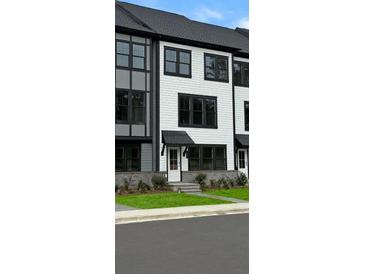 Modern townhome with white siding, black trim, and a welcoming front entrance at 209 Somerset Acres Dr, Summerville, SC 29486