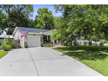 Charming home with a well-manicured lawn, inviting driveway, attached garage and beautiful flowering trees at 414 Birch Ave, Goose Creek, SC 29445
